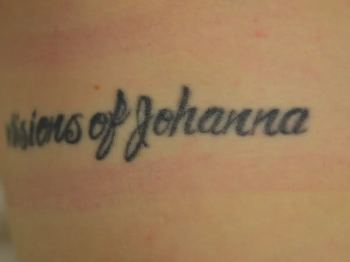 Dense black lettering on the forearm, before treatment at London Real Skin